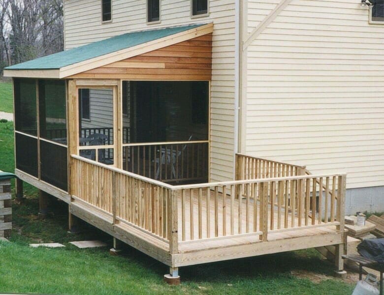 Screened deck with roof opens onto open deck and steps down to yard.