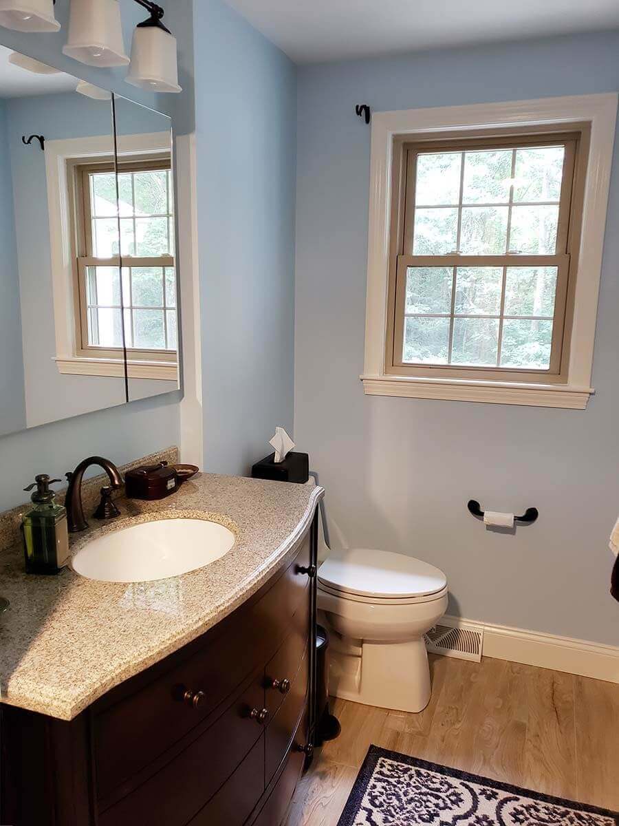 Close view of sculpted bathroom vanity and newly finished floor and window.